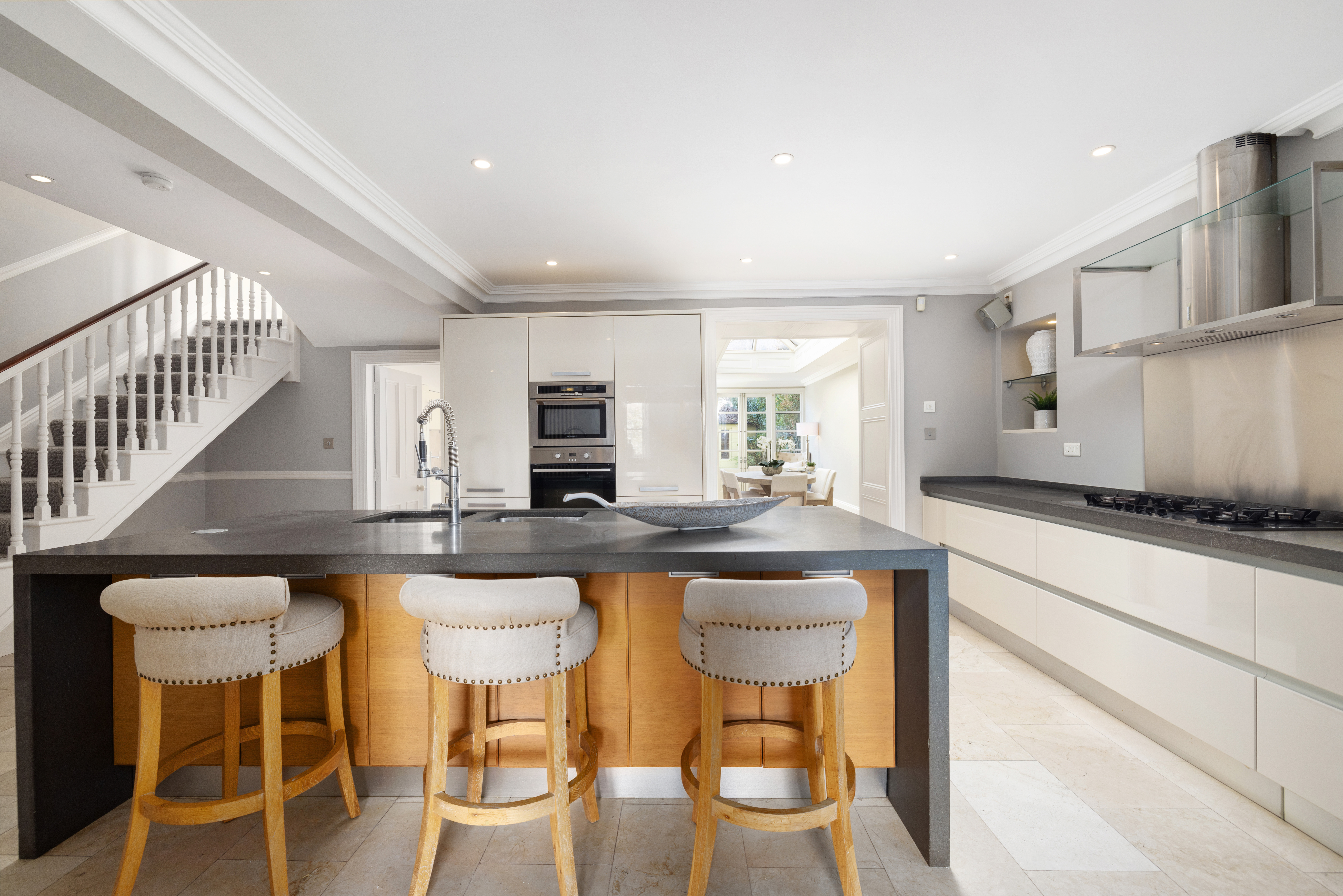 Modern kitchen with island and three bar stools.