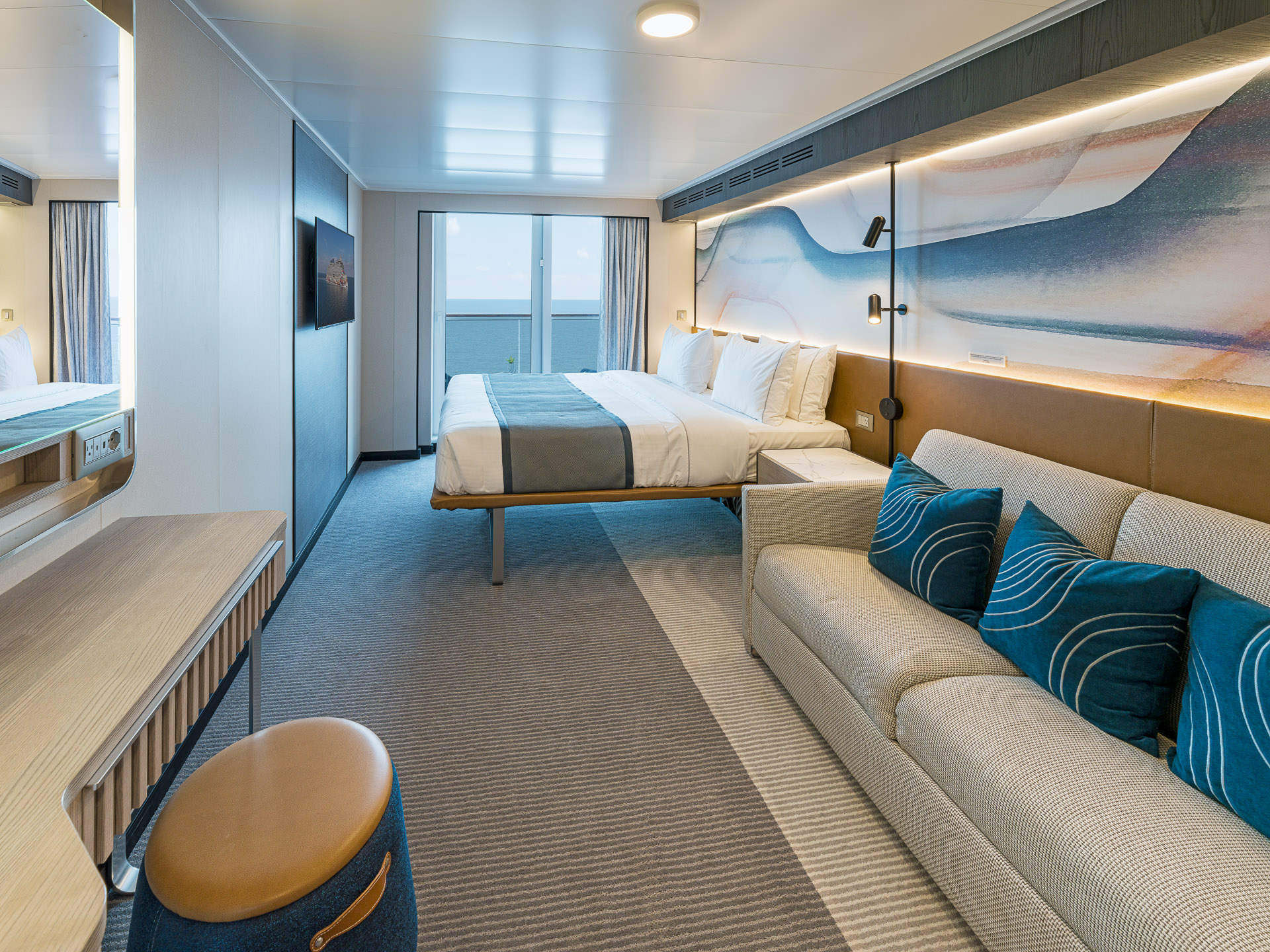 Norwegian Aqua stateroom with bed, sofa, and ocean view.