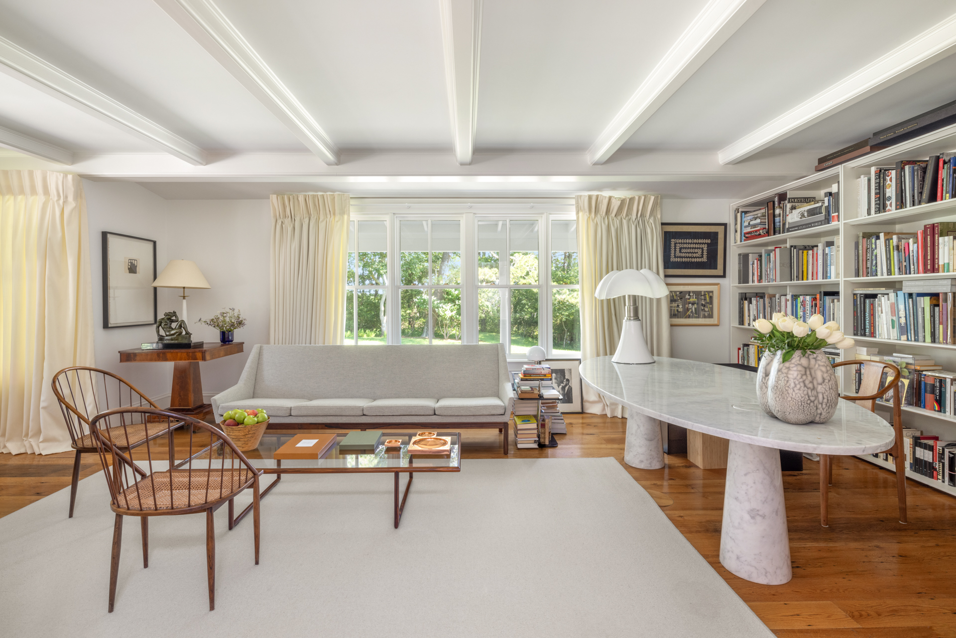 Inside view of a living room featuring a light grey sofa and marble table.