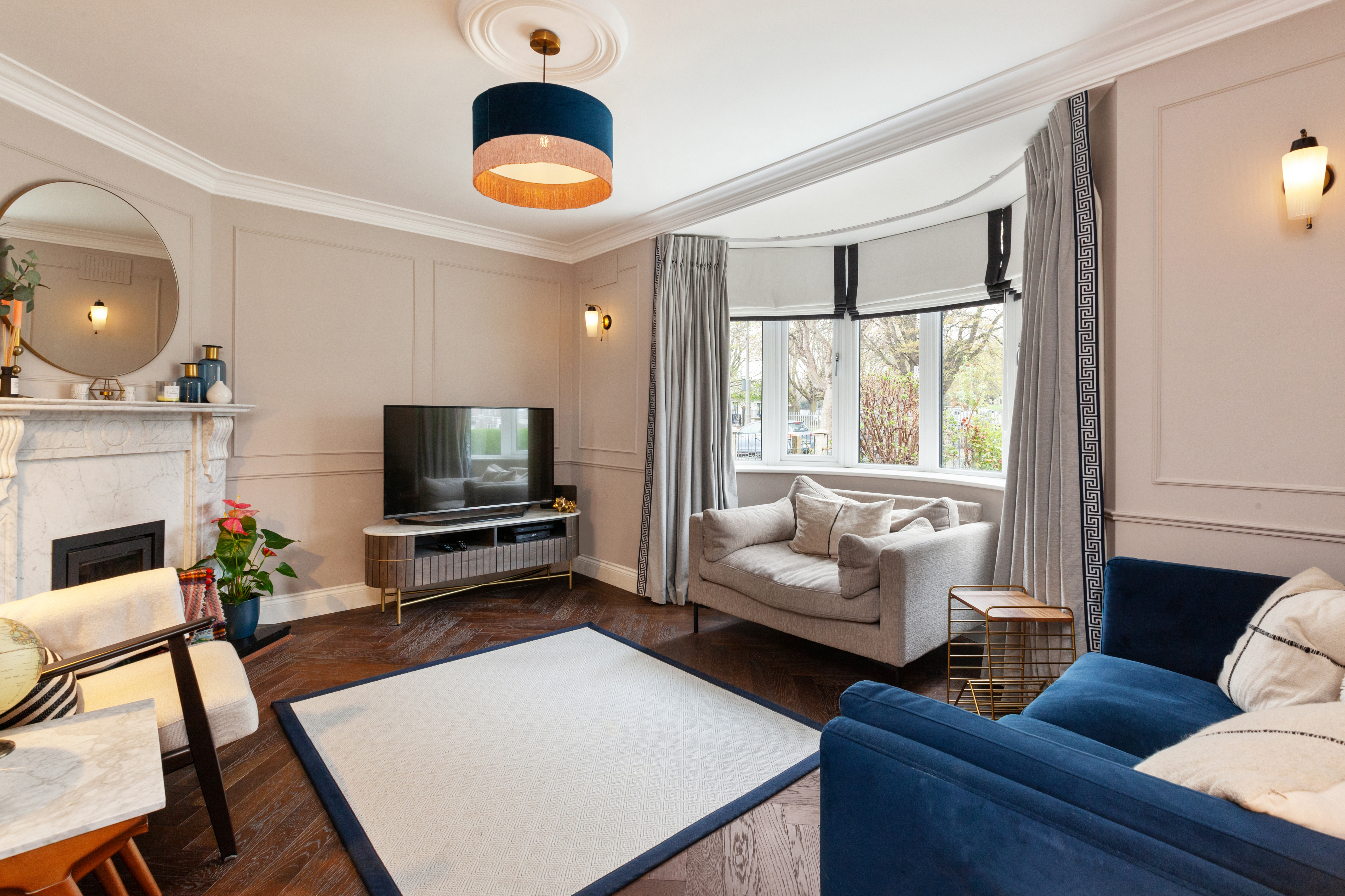 Living room with hardwood floors, sofas, and a television.