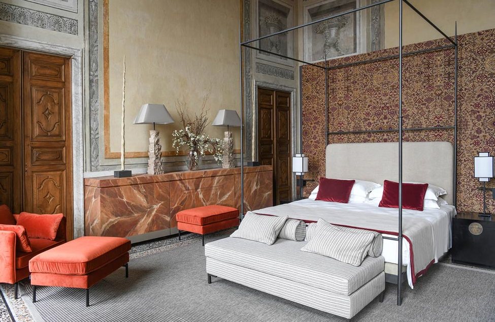 Luxurious hotel room with four-poster bed and stylish decor.