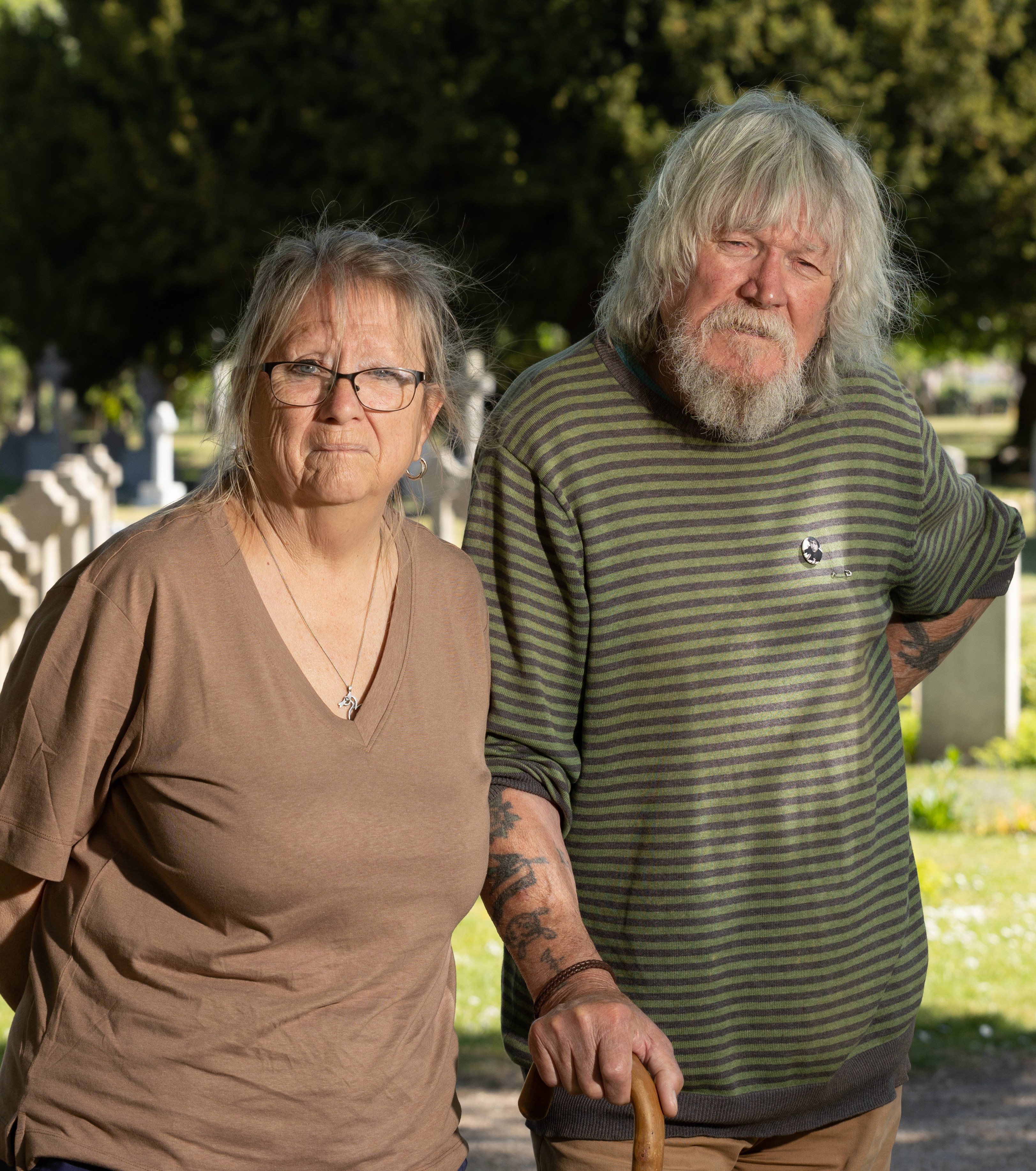 Older couple standing in a cemetery.