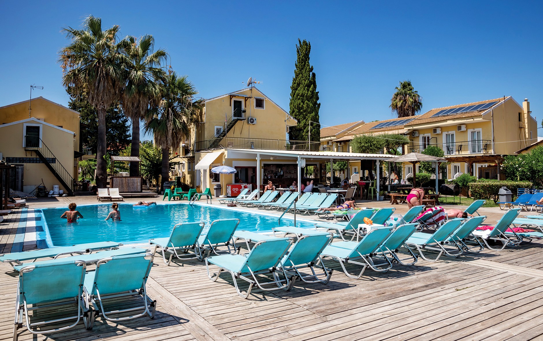 Agnes Beach Hotel pool and surrounding area with lounge chairs and guests.